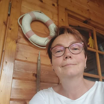 Entspannter Frau im Kosmetikstudio Balance Duisburg, Holzdekor, freundlich.