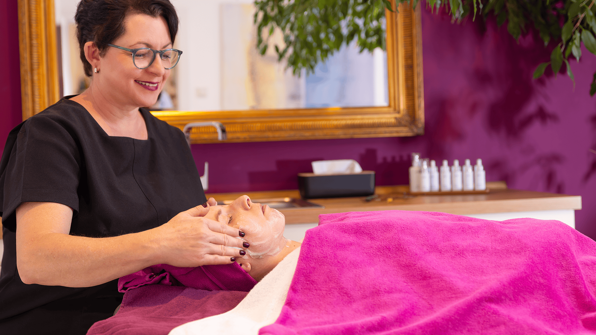 Kosmetikerin bei Gesichtsbehandlung im Schönheitssalon